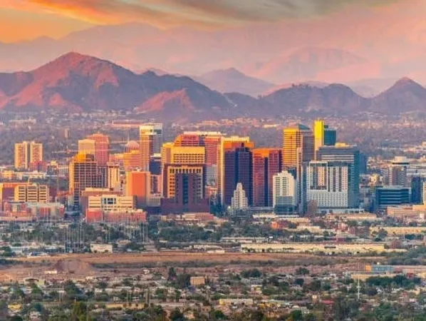City skyline with mountains at sunset.