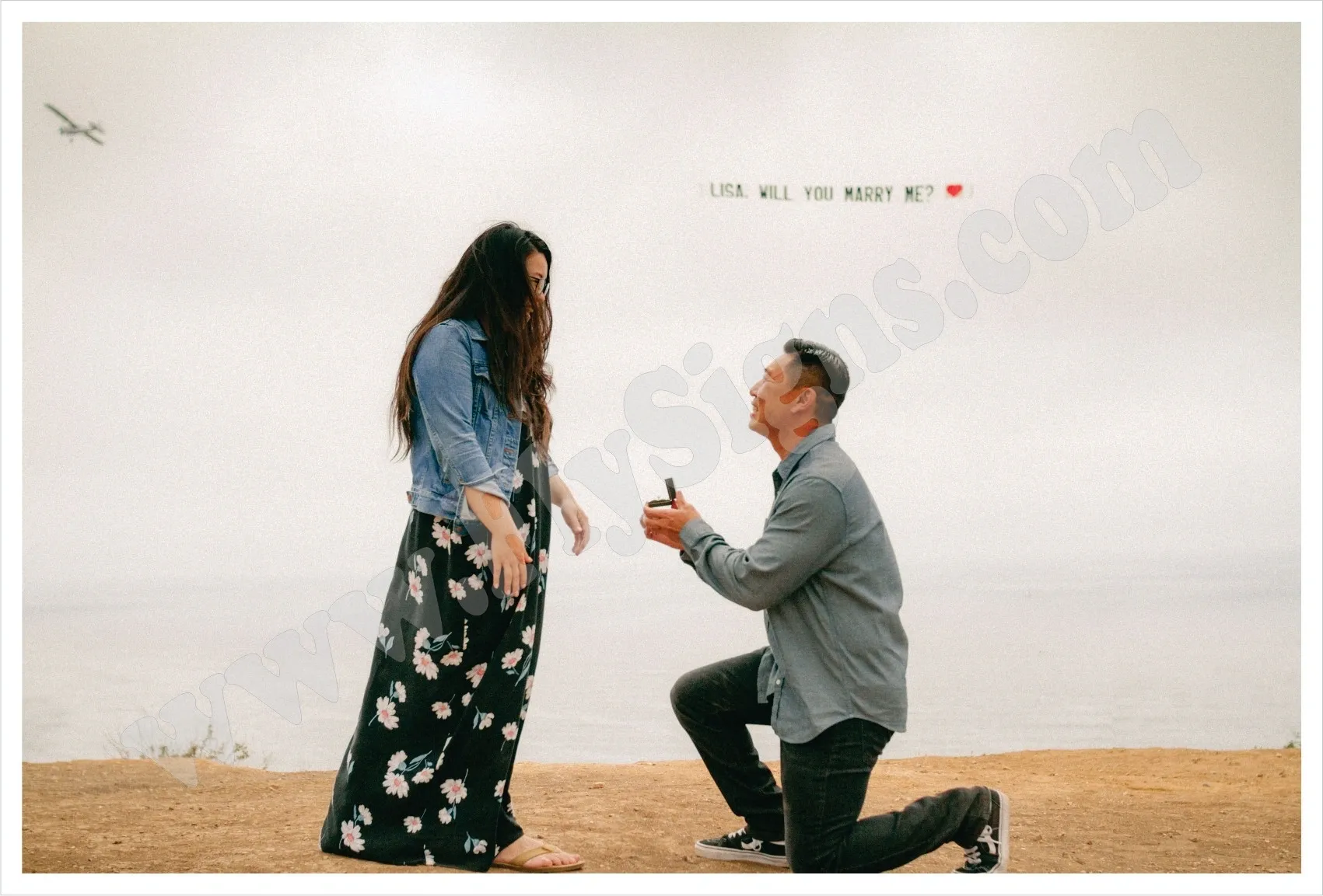 Marriage proposal with airplane banner overhead.